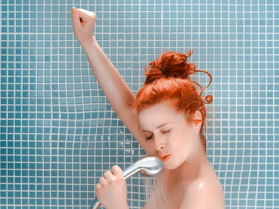 Picture of a woman listening to music and singing in the shower