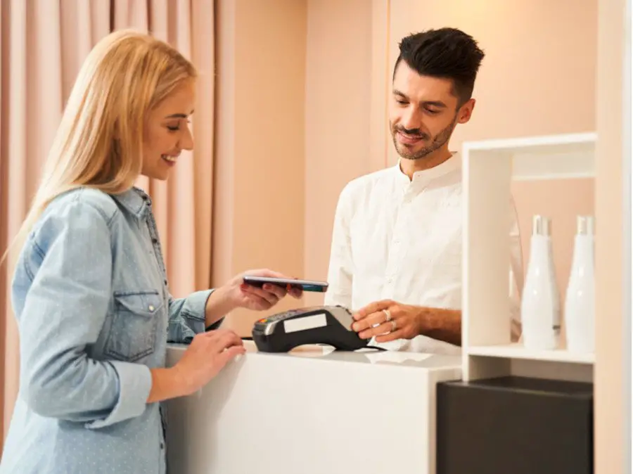 Picture of a woman leaving a tip with a credit card after a massage