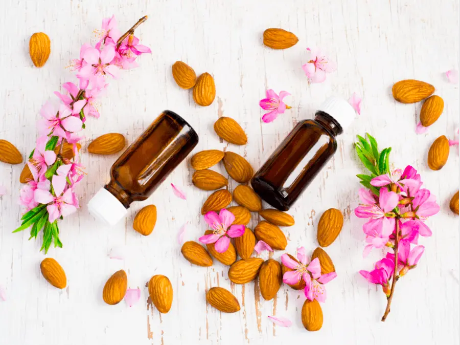 Photo of almond oil, almonds and flowers