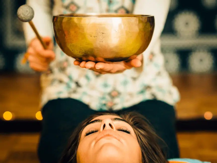Photo of a woman relaxing with a Tibetan singing bowl