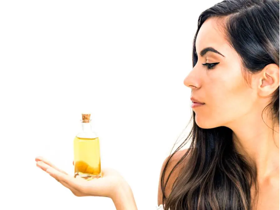 Photo of a woman holding a bottle of argan oil